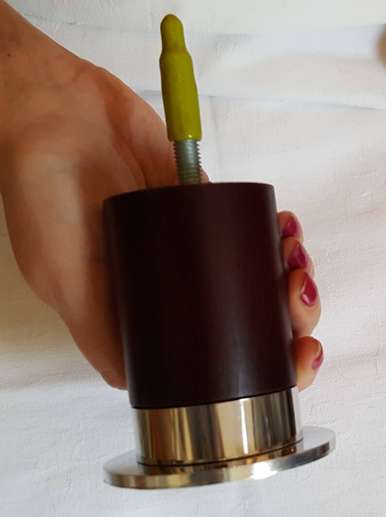 May include: A dark brown wooden furniture leg with a silver metal base and a yellow plastic cap on top.