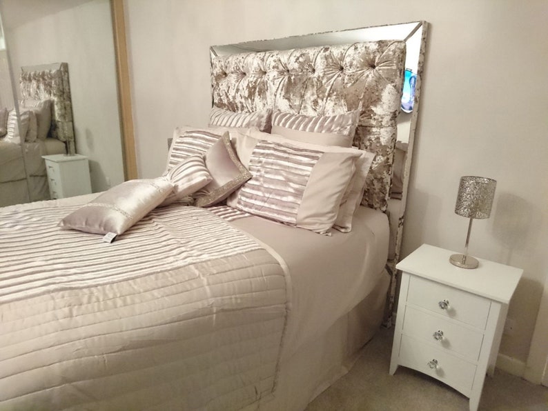 This picture shows a diamond tufted/chesterfield style headboard which is covered in Cristina Marrone Lustro Crushed Velvet in a champagne gold colour. The headboard also has a mirror frame and crystal buttons.