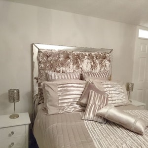 This picture shows a diamond tufted/chesterfield style headboard which is covered in Cristina Marrone Lustro Crushed Velvet in a champagne gold colour. The headboard also has a mirror frame and crystal buttons.
