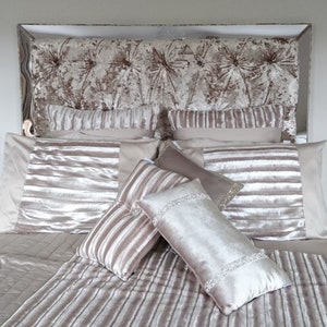 This picture shows a diamond tufted/chesterfield style headboard which is covered in Cristina Marrone Lustro Crushed Velvet in a champagne gold colour. The headboard also has a mirror frame and crystal buttons.