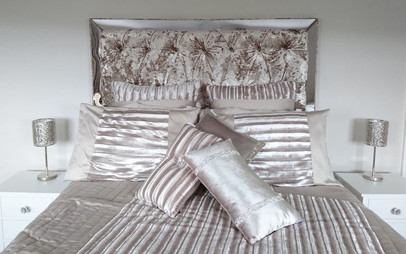 This picture shows a diamond tufted/chesterfield style headboard which is covered in Cristina Marrone Lustro Crushed Velvet in a champagne gold colour. The headboard also has a mirror frame and crystal buttons.