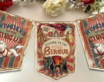Puede incluir: Una guirnalda con temática de circo que consta de tres banderines con ilustraciones de estilo vintage. Los banderines laterales muestran un caballo blanco y un globo aerostático rojo con el texto Wonders of the Circus. El banderín central muestra un elefante, una jirafa, un payaso y el texto Welcome to the Circus y Admit One.