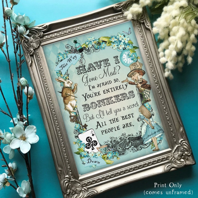 May include: A framed print with a blue background featuring a quote from Alice in Wonderland: "Have I Gone Mad? I'm afraid so. You're entirely bonkers. But I'll tell you a secret. All the best people are."