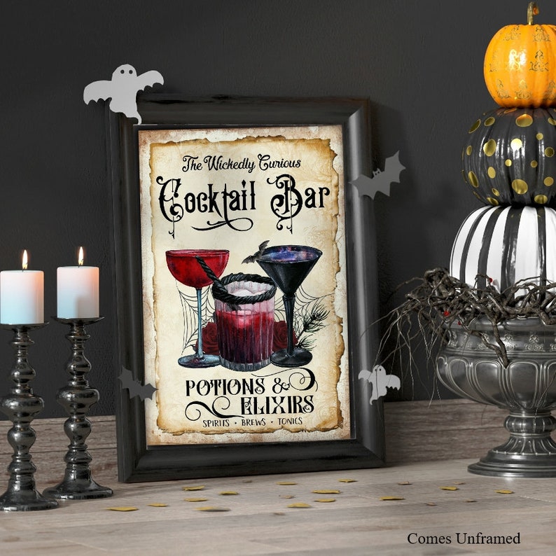 K&ouml;nnte beinhalten: Ein rechteckiger Wandkunstdruck in einem schwarzen Rahmen mit dem Text The Wickedly Curious Cocktail Bar Potions & Elixirs Spirits Brews Tonics. Die Illustration zeigt drei Cocktailgl&auml;ser mit roten und dunklen Fl&uuml;ssigkeiten, Spinnweben und Rosen.