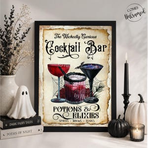 K&ouml;nnte beinhalten: Ein gerahmter Kunstdruck mit dem Titel The Wickedly Curious Cocktail Bar Potions & Elixirs. Das Design zeigt drei Gl&auml;ser mit roten und dunklen Fl&uuml;ssigkeiten, Spinnenweben und eine Fledermaus vor einem Hintergrund im Vintage-Pergamentstil.
