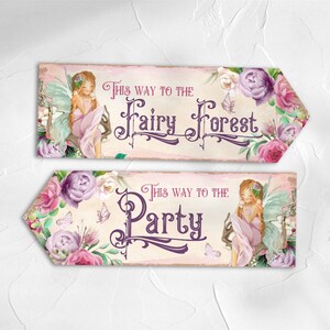 May include: Two rectangular wooden directional signs with pointed ends. The top sign features a fairy, pink and purple flowers, and the text "This way to the Fairy Forest." The bottom sign features a fairy, flowers, and the text "This way to the Party."