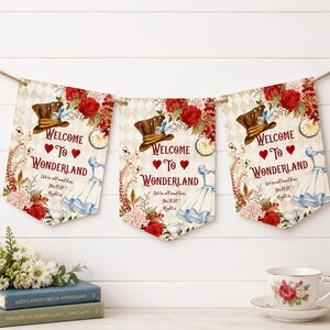 May include: A set of three pennant banners featuring a diamond pattern, red roses, a brown top hat, a blue dress, and a pocket watch. The text reads: Welcome to Wonderland, We're all mad here, You'll fit right in. Each banner is decorated with red hearts.