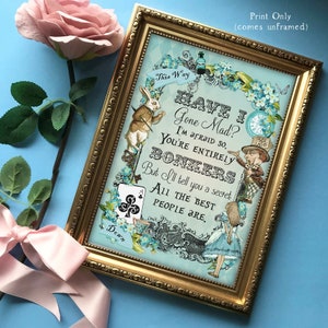 May include: A framed print with a blue background featuring Alice in Wonderland characters, including the White Rabbit and the Mad Hatter. The print includes the text "Have I Gone Mad? I'm afraid so. You're entirely bonkers. But I'll tell you a secret. All the best people are."