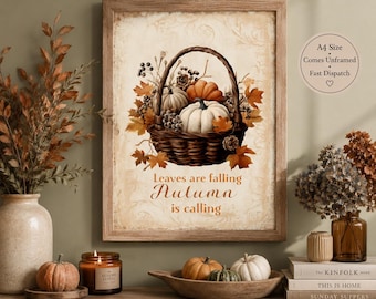 May include: A framed wall art print featuring a woven basket filled with pumpkins, berries, and autumn leaves. The text reads, Leaves are falling Autumn is calling. The background has a vintage cream-colored pattern. A circular graphic states A4 Size, Comes Unframed, Fast Dispatch.