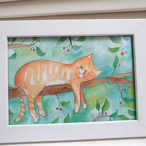 Peut inclure: Peinture à l'aquarelle d'un chat roux se prélassant sur une branche d'arbre, encadrée dans un cadre rectangulaire blanc. L'arrière-plan est turquoise clair avec des feuilles vertes et des baies rouges. Le chat a une expression détendue.