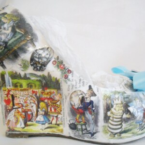 May include: White wedge shoe with a blue bow. The shoe is decorated with images from Alice in Wonderland, including Alice, the Queen of Hearts, and the Mad Hatter.