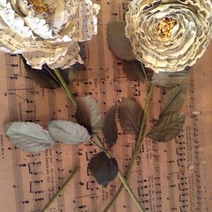 flor de papel musical em um fio verde florista fita adesiva embrulhado com folhas florais falsas