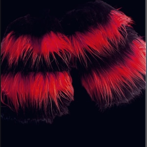 May include: A pair of black and red faux fur wrist cuffs. The cuffs are made of soft, fluffy fur with a black base and red tips.