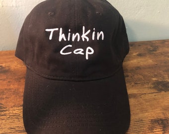 Thinkin Cap- Black Hat with White Letters - Reverses on the Back to say “Not Thinkin”