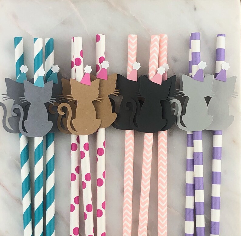 May include: Set of six paper straws with a cat wearing a party hat design. The straws have different patterns: teal and white stripes, white with pink polka dots, pink and white chevron, and purple and white stripes.