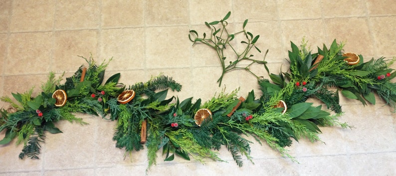 Fresh Christmas garland, mantlepiece. scented dried oranges, Bay leaves, evergreen fir, red berries, cinnamon sticks. Smells divine image 2