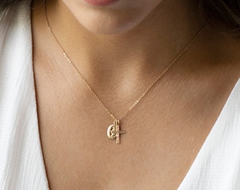 May include: A gold chain necklace with a small cross and a round pendant featuring a religious image.