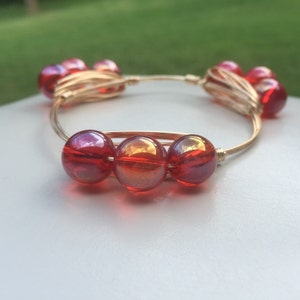 Three red iridescent round beads wire wrapped on gold wire, bourbon and bowties inspired style