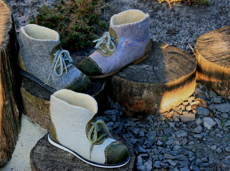 May include: Three pairs of felt boots with green and blue accents. The boots are made of wool and have a soft, comfortable feel.