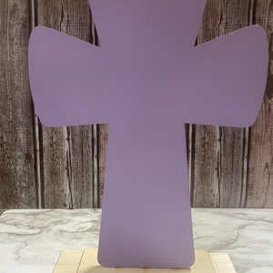 May include: A lavender wooden cross with a simple design, standing on a wooden base.