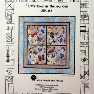 May include: A quilt pattern titled "Flutterbies in the Garden" with a central design of butterflies and flowers. The pattern is surrounded by a light blue border and a black and white patterned frame. The text "With Needle and Thread" is also visible.