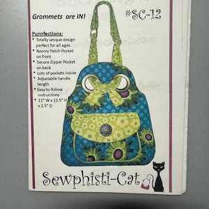May include: A sewing pattern for "Erica's Bag" with a blue and green floral design. The bag features a bow, a front pocket, and a cat silhouette. The pattern includes instructions and measurements of 11" W x 12.5" H x 2.5" D.