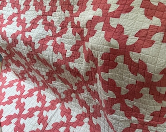 May include: A pink and white quilt with a repeating pattern of curved shapes. The quilt is made of cotton fabric and is hand-stitched.