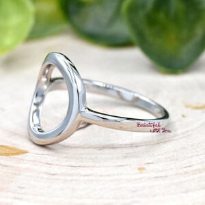 May include: A silver ring with a large open circle design. The ring is engraved with the words "Beautiful with You".