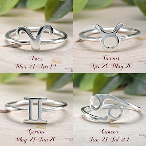 Puede incluir: Cuatro anillos de plata con s&iacute;mbolos del zod&iacute;aco. Los anillos est&aacute;n dispuestos en una cuadr&iacute;cula. Los s&iacute;mbolos son Aries, Tauro, G&eacute;minis y C&aacute;ncer. Las fechas de cada signo del zod&iacute;aco se enumeran debajo del s&iacute;mbolo.