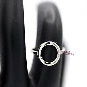 May include: A silver ring with a large, round, open circle design.