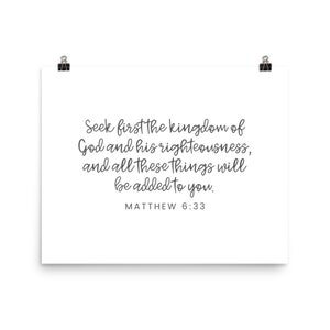 This 16x20 inch bible verse poster says Seek first the kingdom of God and his righteousness and all these things will be added to you. Matthew 6 33. The background is white and the text is gray and mostly in a cursive font.