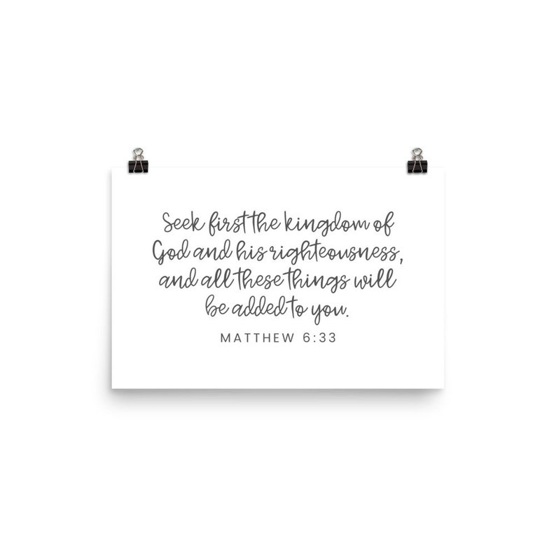 This 12x18 inch bible verse poster says Seek first the kingdom of God and his righteousness and all these things will be added to you. Matthew 6 33. The background is white and the text is gray and mostly in a cursive font.