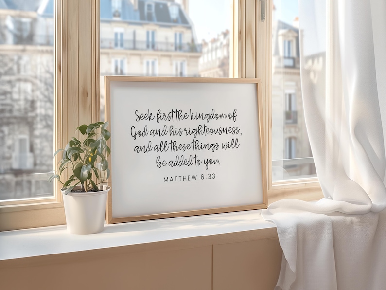 This mockup shows what this unframed Matthew 6 33 Bible verse poster could look like in a frame. It has a white background and gray text. It says seek first the kingdom of God and his righteousness and all these things will be added to you.