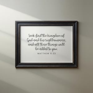 This mockup shows what this unframed Matthew 6 33 Bible verse poster could look like in a black wood frame. It has a white background and gray text. It says seek first the kingdom of God ...