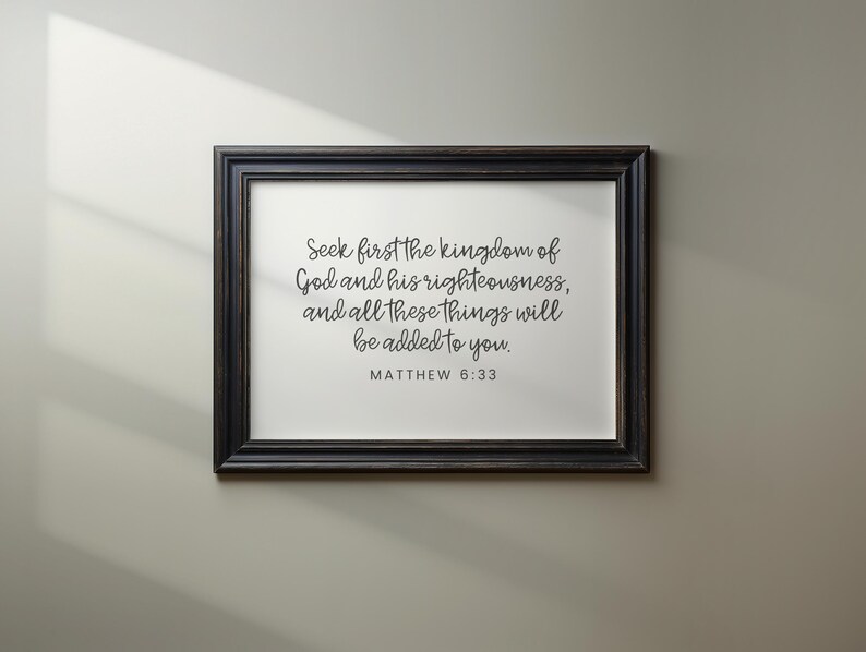 This mockup shows what this unframed Matthew 6 33 Bible verse poster could look like in a black wood frame. It has a white background and gray text. It says seek first the kingdom of God ...
