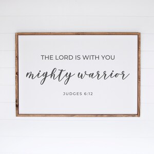 May include: A framed sign with the text "The Lord is with you mighty warrior" and the scripture reference "Judges 6:12".