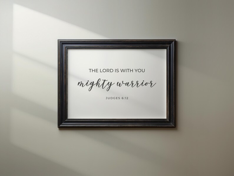 May include: A black framed print with the text "The Lord is with you mighty warrior" and the scripture reference "Judges 6:12".