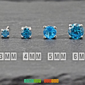 May include: Four silver stud earrings with blue topaz gemstones. The earrings are shown in sizes 3mm, 4mm, 5mm, and 6mm.