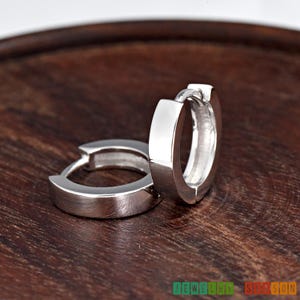 May include: A pair of silver hoop earrings with a polished finish. The earrings are simple and elegant, and they would make a great gift for any occasion.