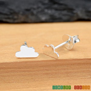May include: A pair of silver cloud-shaped stud earrings. The earrings are small and delicate, and they would make a great gift for someone who loves clouds.