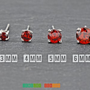 May include: Four silver stud earrings with red gemstones. The earrings are shown in increasing size from left to right, measuring 3mm, 4mm, 5mm, and 6mm.