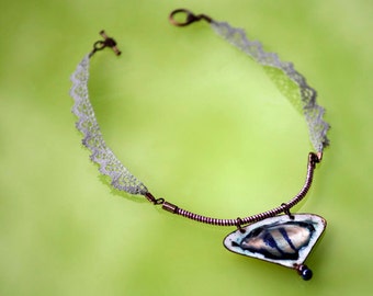 May include: A delicate silver lace necklace with a copper wire and a pendant featuring a white and blue enamel design.