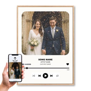 May include: A framed wedding photo of a smiling couple, with a music player graphic overlay. The music player displays the song title "OUR FIRST DANCE" and has a play button. The frame is light brown.