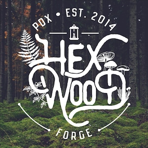 May include: White logo design on a forest background. The logo reads "HEX WOOD FORGE" with additional text: "PDX • EST. 2014". The design includes illustrations of a fern, mushrooms, and other botanical elements. The background features a blurred forest scene.