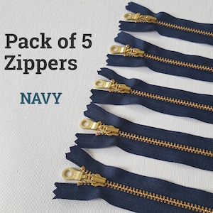 Könnte beinhalten: Packung mit 5 marineblauen Reißverschlüssen mit goldenen Metall-Schiebern.