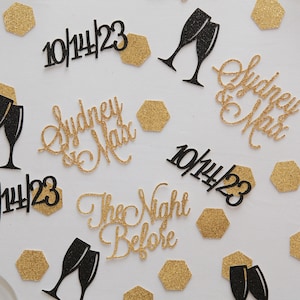 Gold and black rehearsal dinner decorations. Custom bride and groom names, wedding dates, champagne glasses and hexagons
