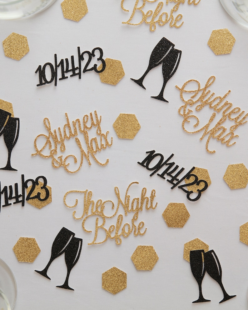 Gold and black rehearsal dinner decorations. Custom bride and groom names, wedding dates, champagne glasses and hexagons