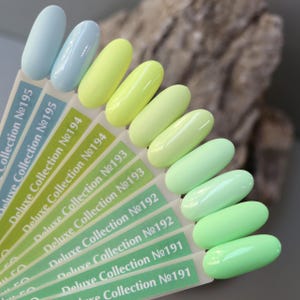 May include: A set of ten nail polish colours in a gradient from light blue to green. The colours are labelled with numbers from 191 to 195. The labels read "Deluxe Collection No. 191" to "Deluxe Collection No. 195".