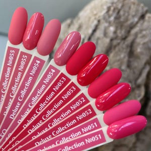 Puede incluir: Una carta de colores con diez tonos diferentes de esmalte de uñas rosa. Los tonos van del rosa claro al rosa oscuro. Cada tono está etiquetado con un número, comenzando con 051 y terminando con 055. La carta está hecha de papel blanco con texto negro.