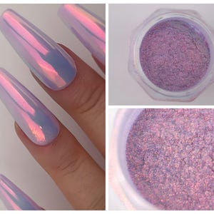 Könnte beinhalten: Nahaufnahme von schillerndem Nagellack auf langen, Sarg-förmigen Nägeln. Der Lack wechselt die Farbe von Rosa zu Blau. Außerdem wird ein Behälter mit feinem, schimmerndem violettem Puder gezeigt, wahrscheinlich Nailart-Pigment.
